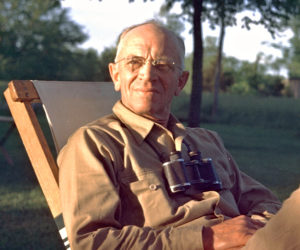 Aldo Leopold sitting with binoculars